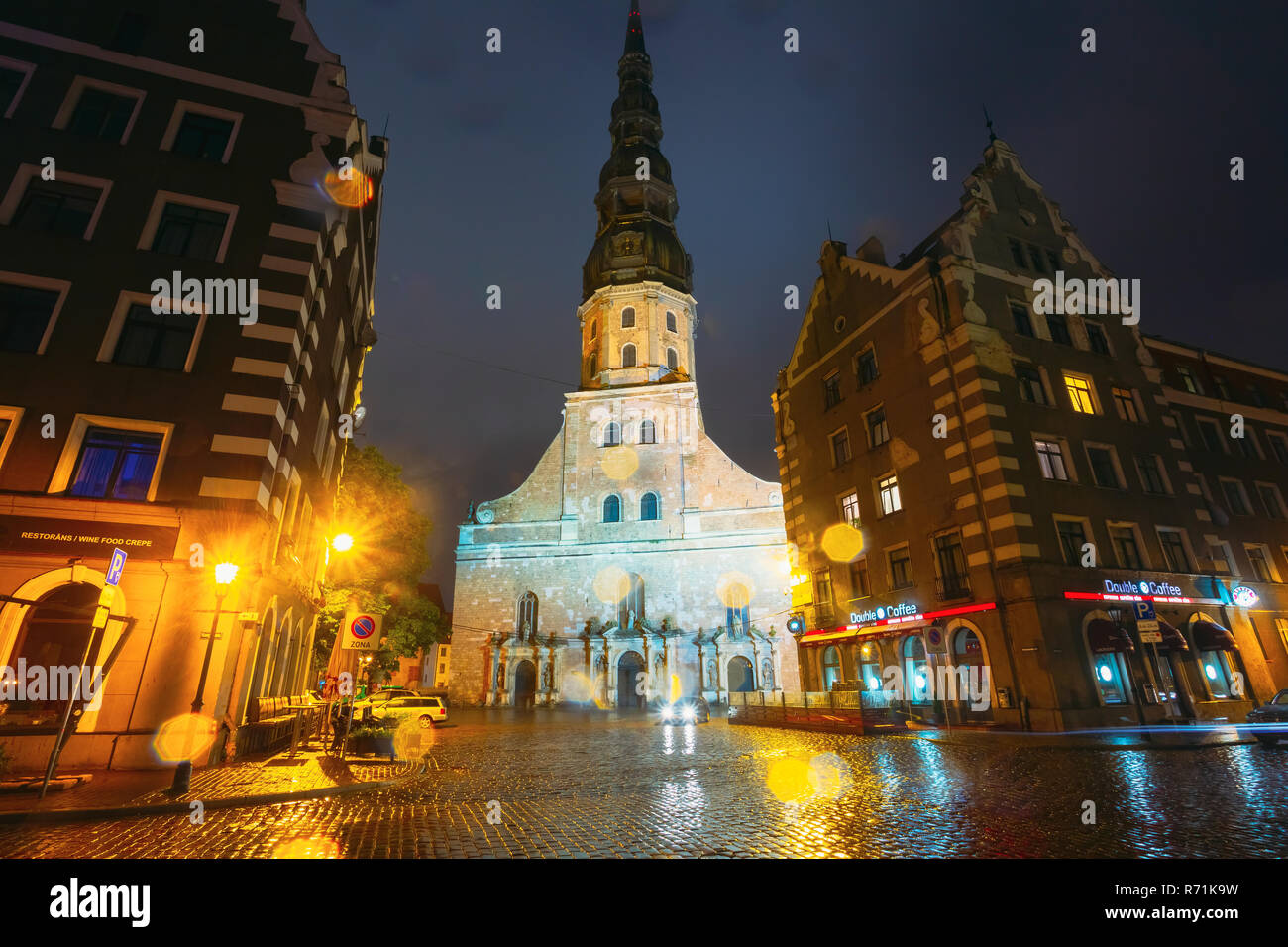 Riga, Lettonia - 4 Luglio 2016: vista notturna della chiesa di San Pietro nella Città Vecchia di Riga in Lettonia. Strada illuminata. Foto Stock