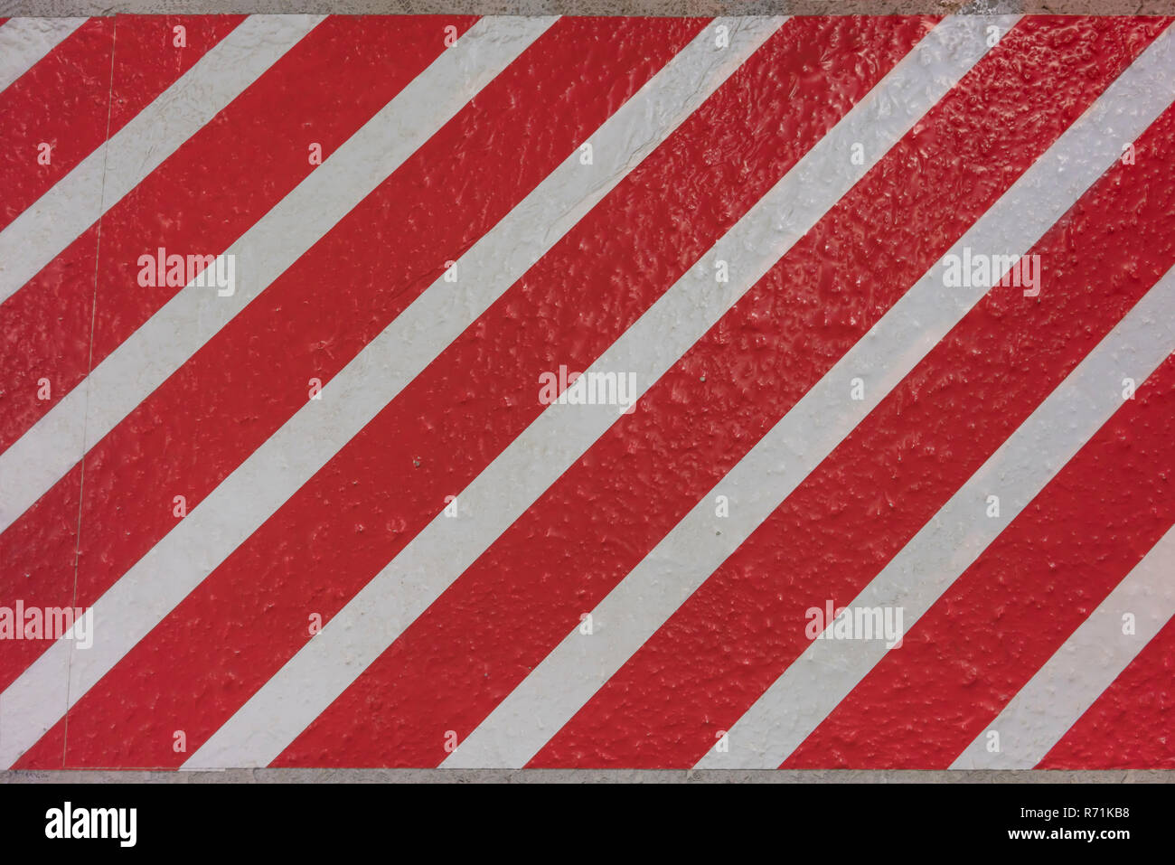 Sticker texture con strisce rosse e bianche in diagonale su una superficie di cemento. Foto Stock