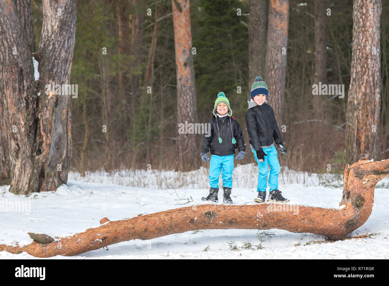 Due belle e allegro fratelli giocando in il bosco d'inverno. Foto Stock