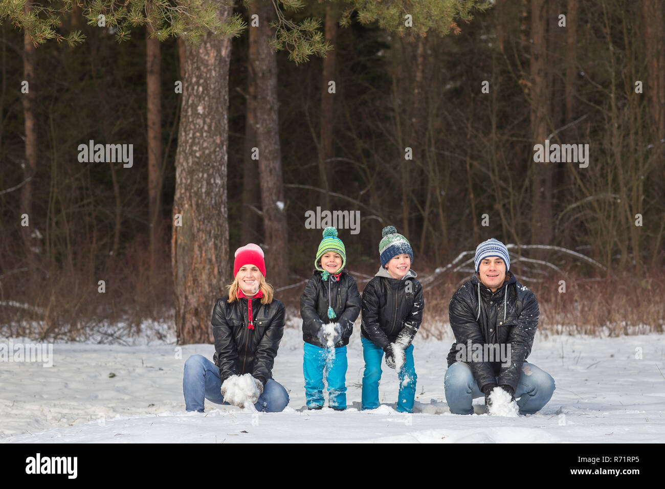 La famiglia felice passeggiate e giocare con la neve in inverno forest Foto Stock