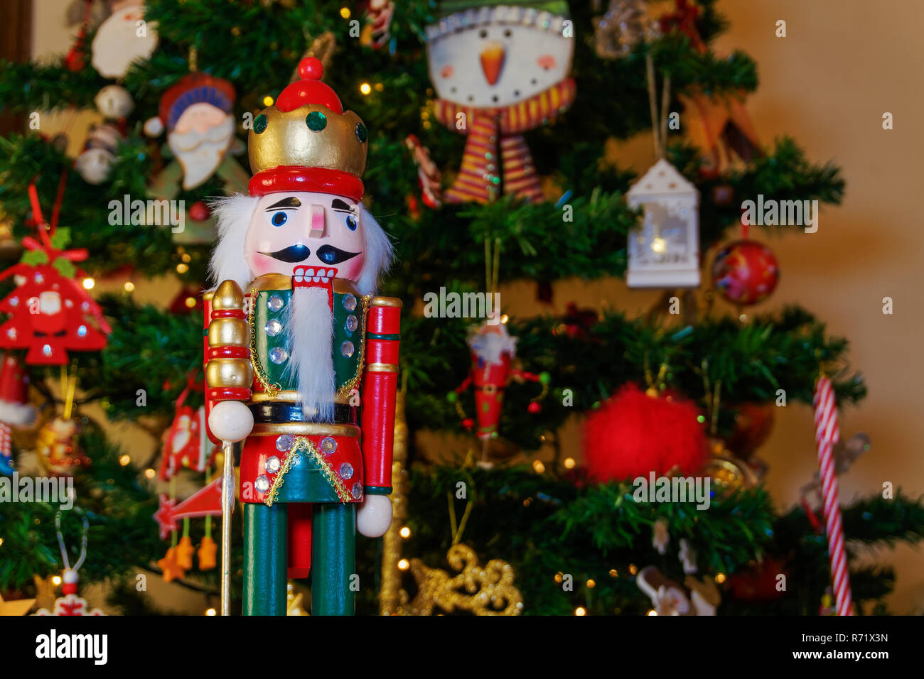 Grande stagno soldato schiaccianoci su di un albero di Natale con sfondo  sfocato. Giocattolo stagionale figura prima di un illuminato albero di  Natale artificiale Foto stock - Alamy