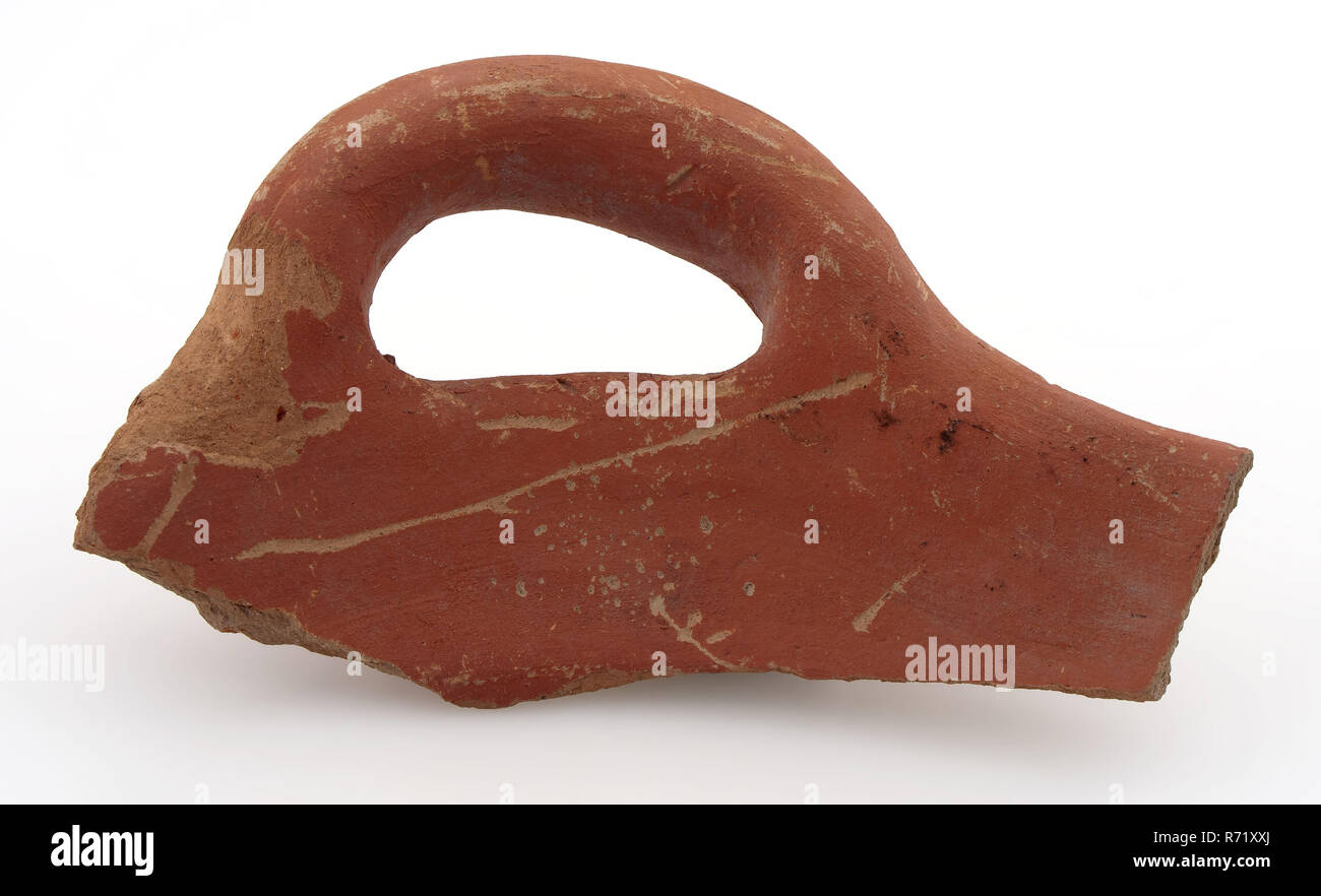 Frammento di confine di terracotta rossa con grossa salsiccia orecchio, non smaltate, cuocere il piatto porta-utensili da cucina terraglie ceramiche, girato a mano a mano al forno a forma di frammento di bordo del grande vaso di terracotta. Giacente salsiccia orecchio. Orange shard bagliore rosso fianco inclinato. Sporgenza al di sotto del bordo sul lato esterno di archeologia non smaltate il centro città di Rotterdam Stadsdriehoek Mariniersweg Hoogstraat terracotta indigeni reperto archeologico nel suolo Hoogstraat Mariniersweg 1983. Foto Stock