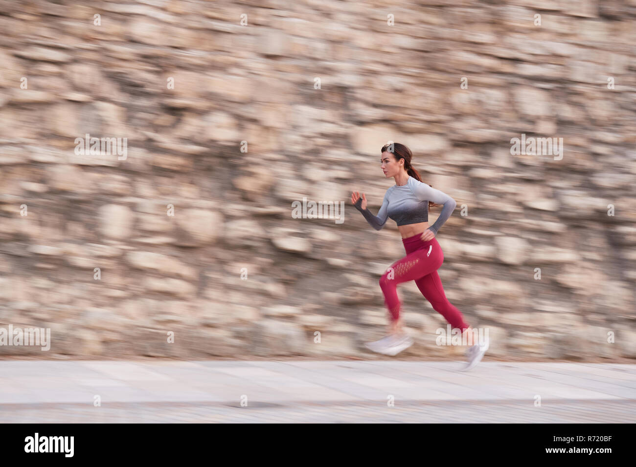 Single Caucasian Female jogging in un centro della città al tramonto Foto Stock