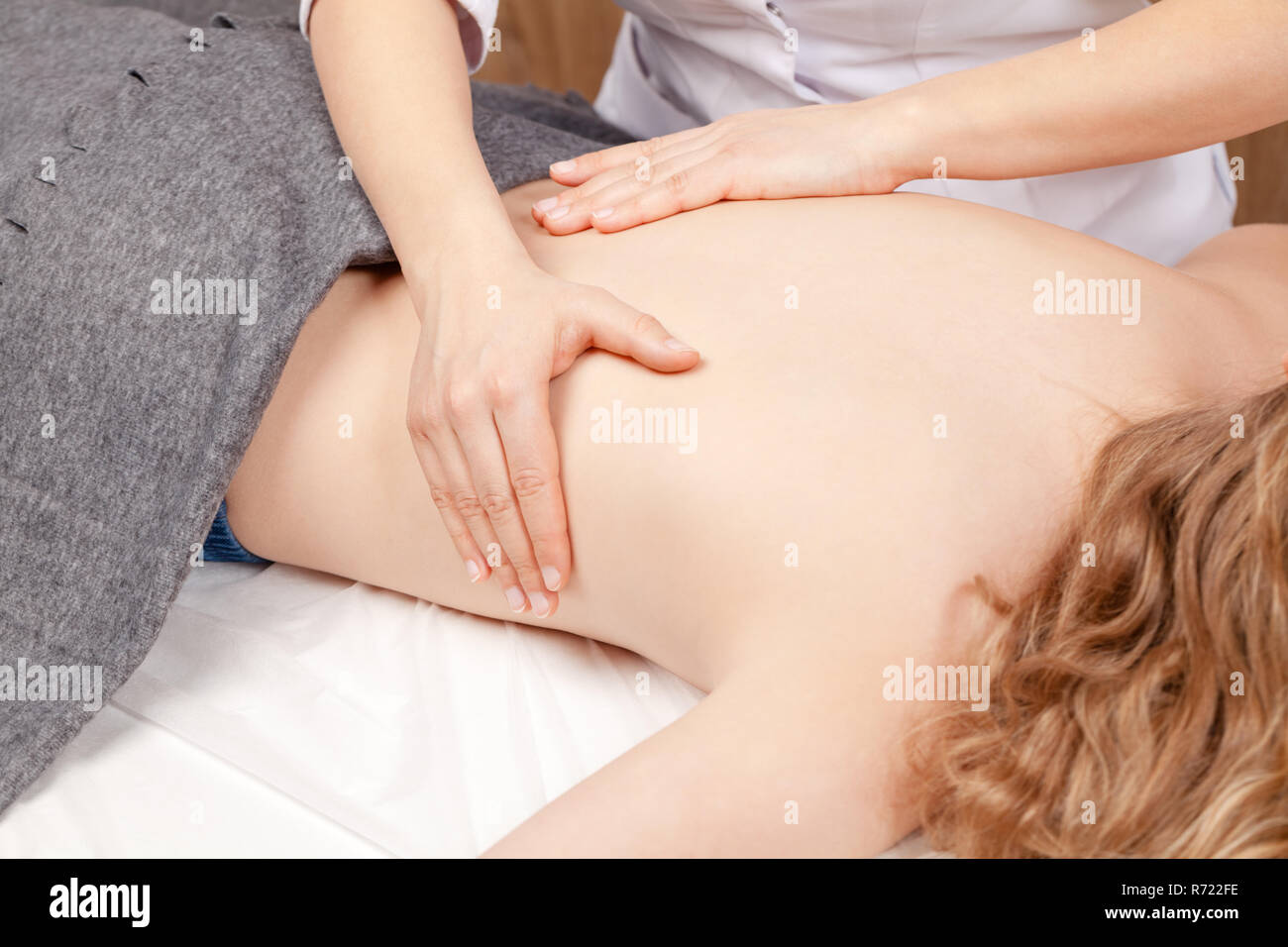 Preteen ragazza indietro la regione lombare manipolato da o osteopatica chiropratica terapista manuale o il medico - massaggio medico concept Foto Stock