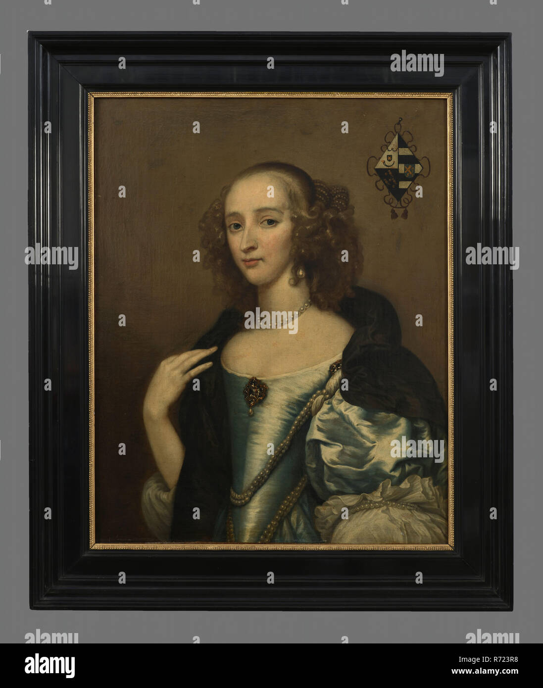 Nei dintorni di A. Hanneman?, Ritratto di Agatha van Rhijn (1627-1673), ritratto dipinto biancheria da materiale di pittura a olio, rettangolare verticale ritratto di donna in rappresentanza di Agatha van Rhijn moglie di Pieter de Groot a mezza lunghezza guardando a sinistra sullo sfondo di luce. Tubo di ricci (à la Sévigné) blu abito in seta con strette corpetto maniche convessa a forma di nave spilla di clivaggio collane di perle attorno al collo e la parte superiore del corpo scialle nero. Mano destra tocca la spalla destra. Lato destro a forma di diamante stemma della famiglia (Rhijn e cornette de Groot?) lato inverso della stemma araldico Agatha van Rijn Rhijn Pieter de Groot Foto Stock