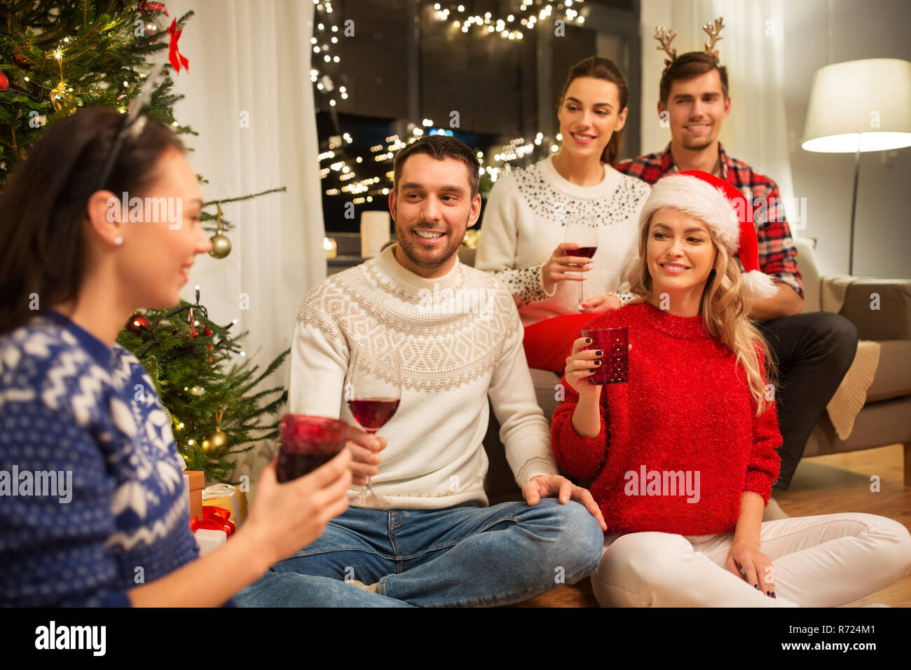 Amici festeggiano il Natale e bere il vino Foto Stock