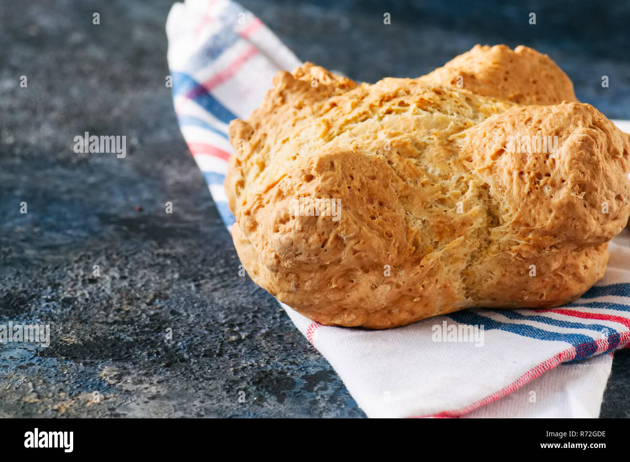 Irlandese tradizionale pane soda su un asciugamano su una pietra blu sullo sfondo. Foto Stock