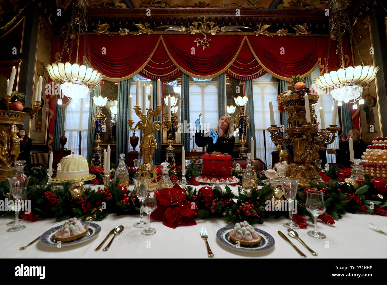 Kim Jupp del Royal Pavilion, Brighton, mette il tocco finale al tavolo nella sala banchetti del padiglione in vista del Natale annuale banchetto. Foto Stock