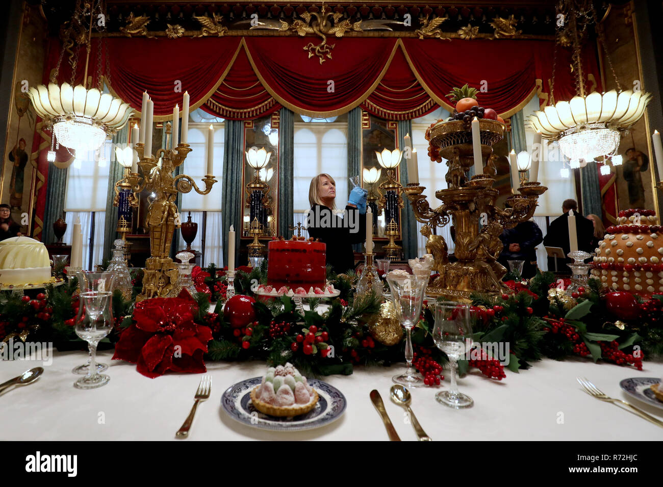 Kim Jupp del Royal Pavilion, Brighton, mette il tocco finale al tavolo nella sala banchetti del padiglione in vista del Natale annuale banchetto. Foto Stock