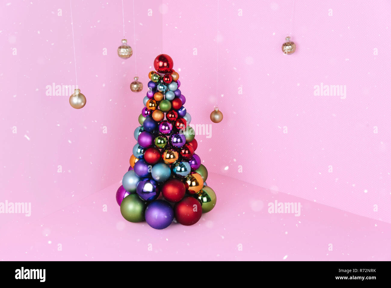 Albero di Natale fatto di decorazione a sfera su sfondo rosa. Foto Stock