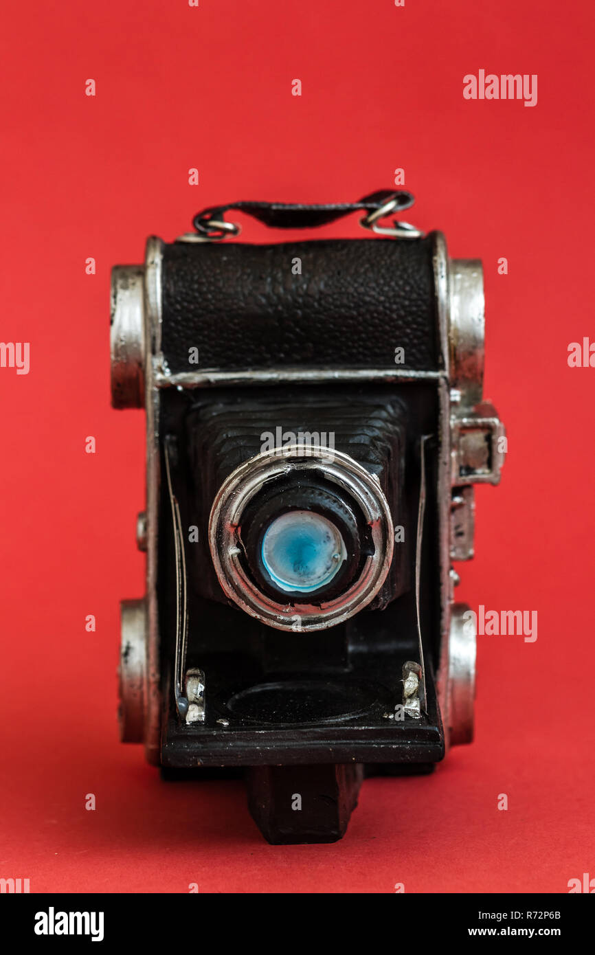 Decorativo fotocamera nostalgico figurina su sfondo rosso Foto Stock