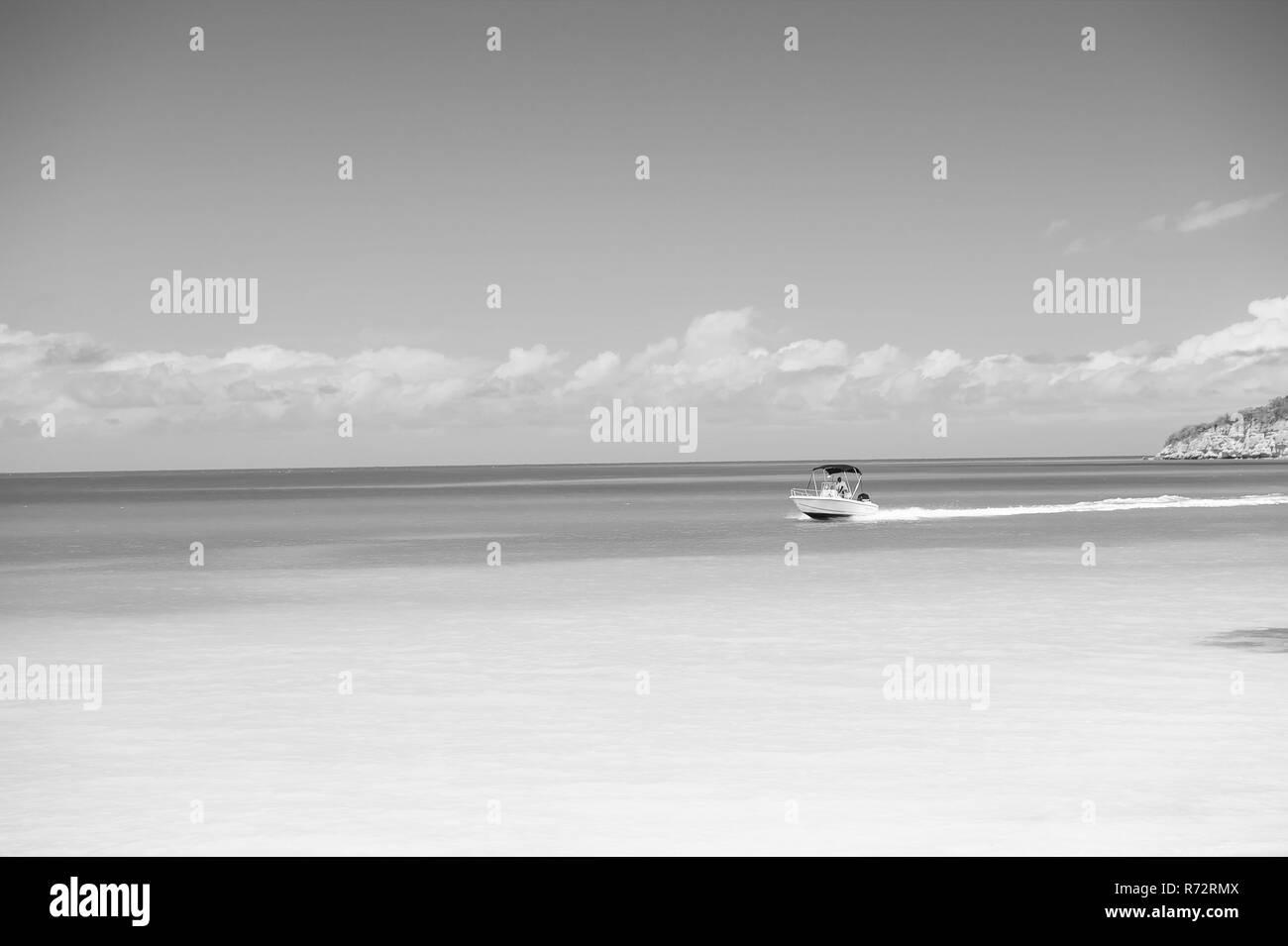 Imbarcazione a motore galleggiante sul mare azzurro Oceano o superficie di acqua in st Johns, Antigua, sulla giornata di sole sul cielo blu sullo sfondo. La vacanza estiva, viaggiare wanderlust concetto. Foto Stock