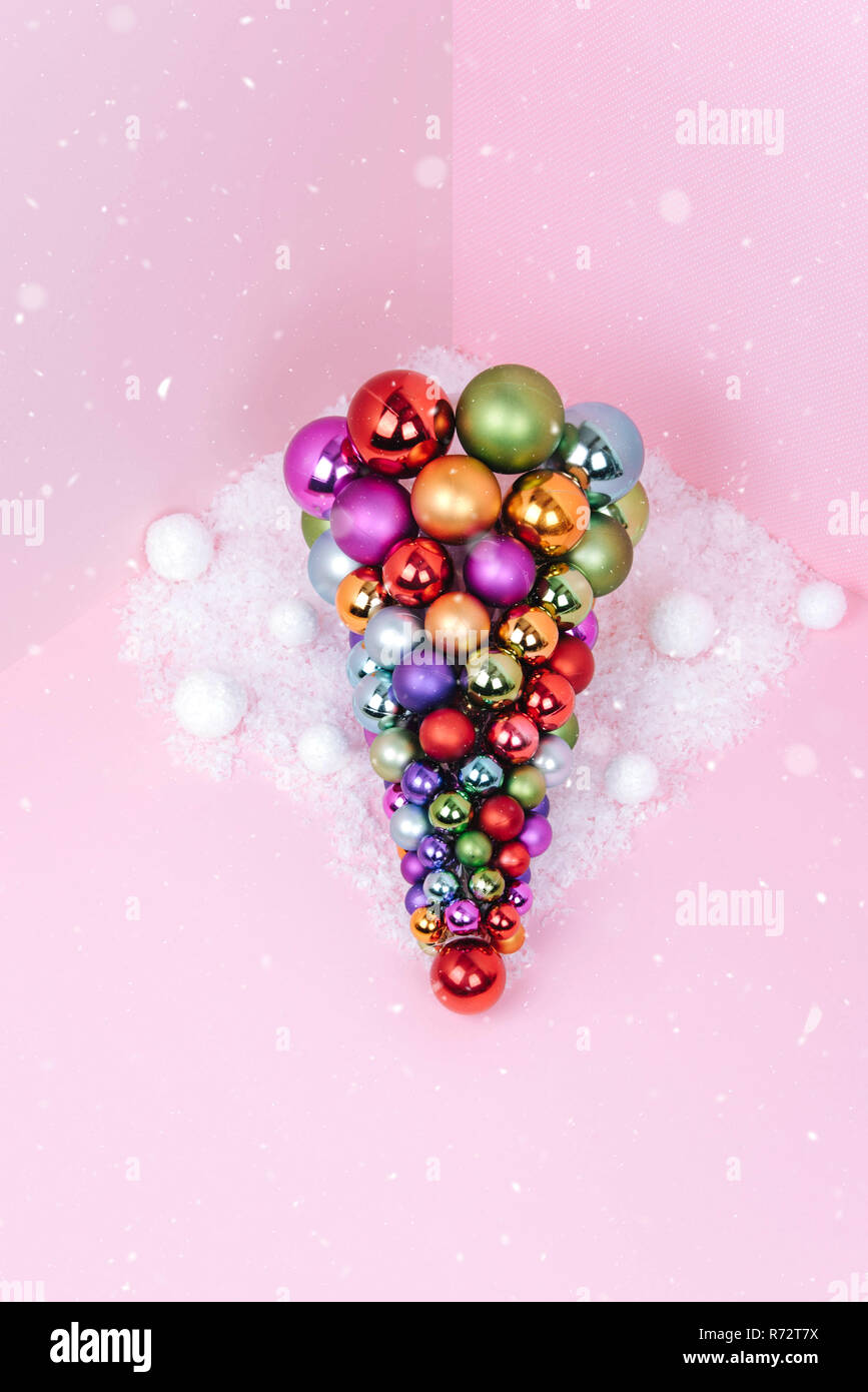 Albero di Natale fatto di decorazione a sfera su sfondo rosa. Foto Stock