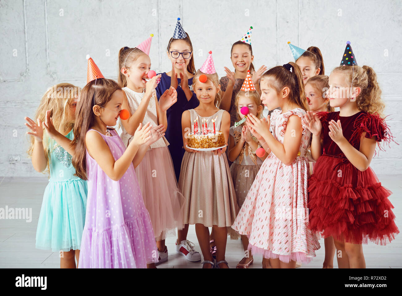 I bambini con una torta di compleanno divertirsi. Foto Stock