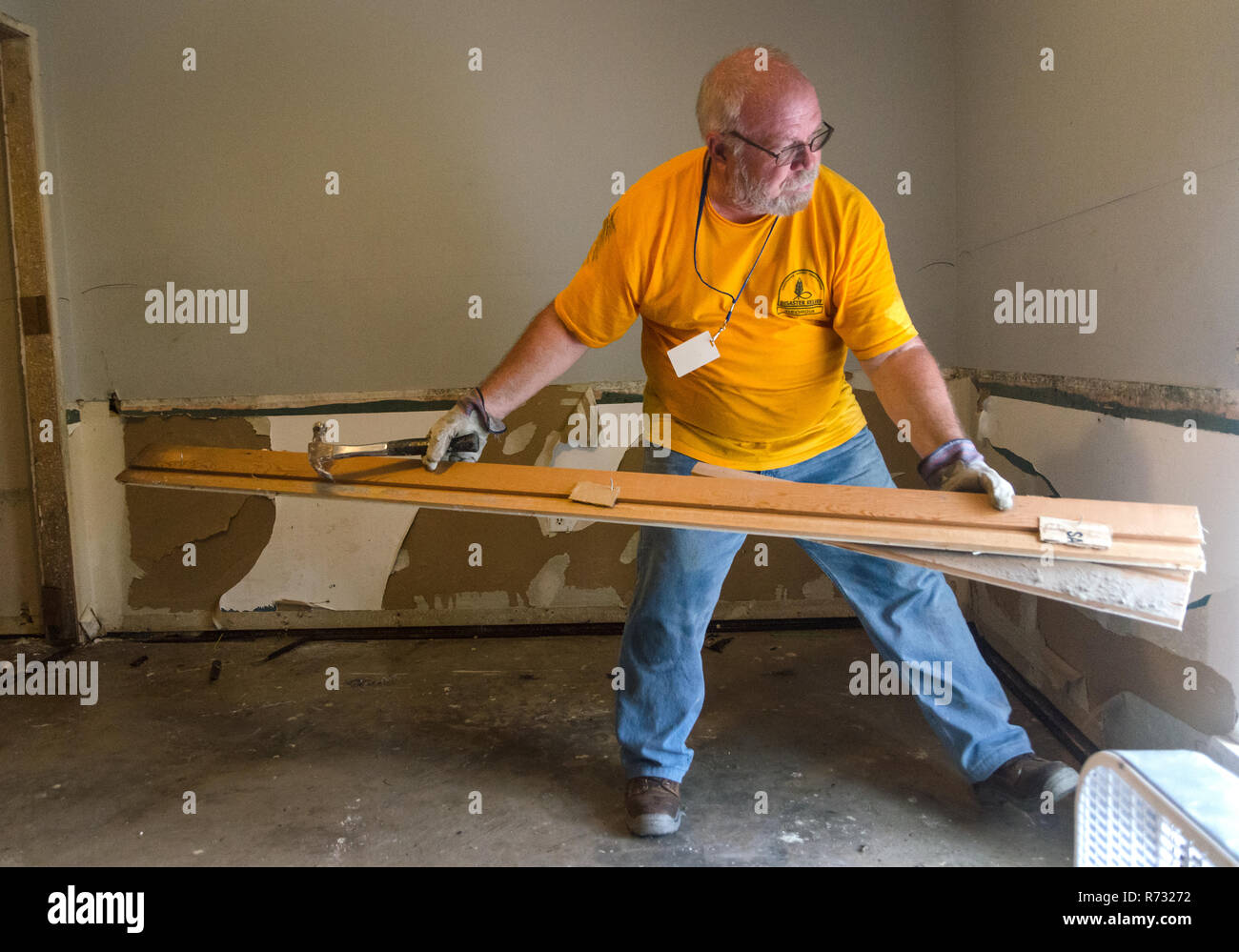 Un Southern Battista Disaster Relief volontario rimuove il legno danneggiato da una casa dopo un allagamento in Denham Springs, Louisiana. Foto Stock