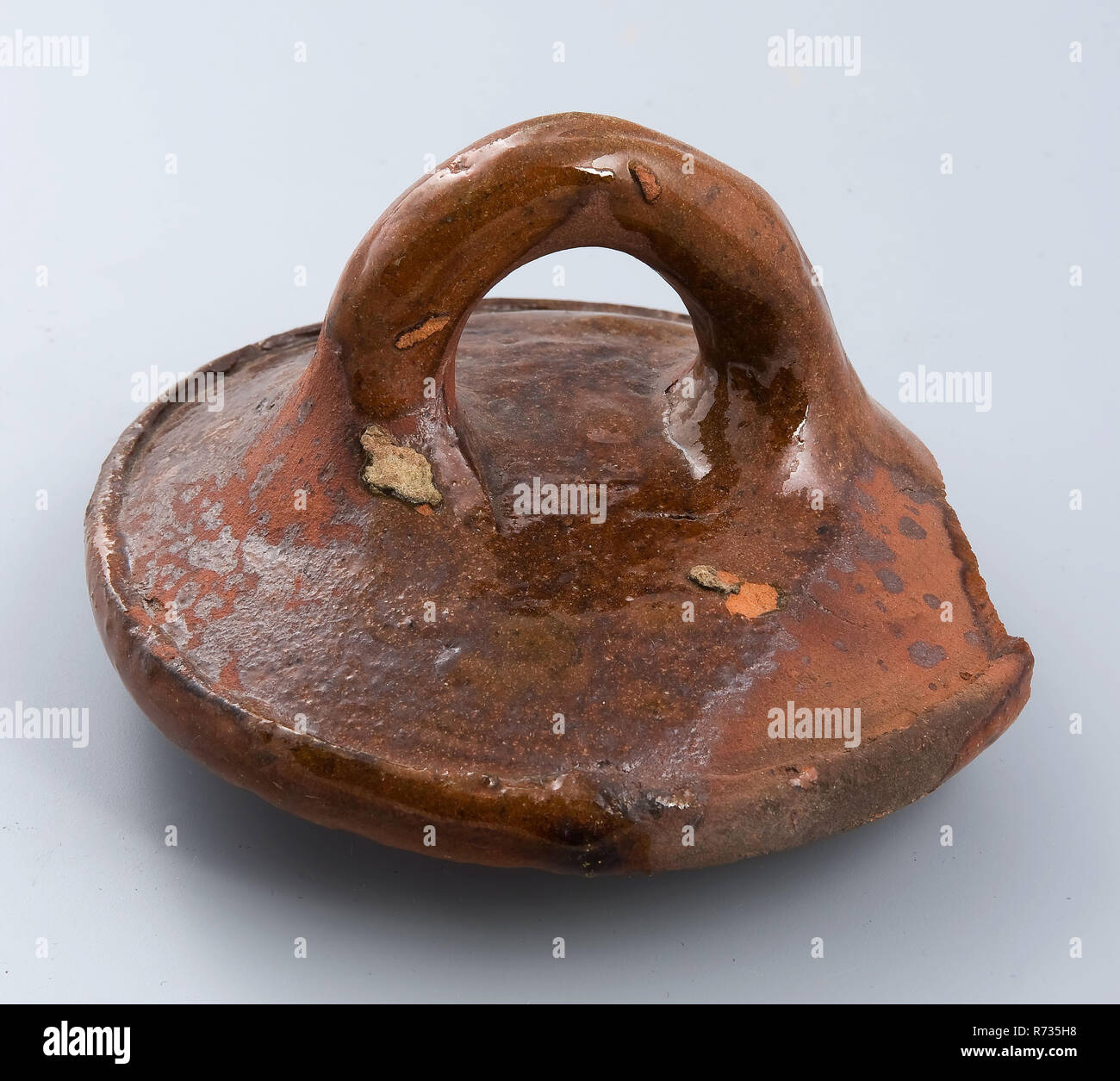 Frammento di coperchio di terracotta, con salsiccia orecchio, rim con un piccolo labbro, chiusura coperchio suolo trovare ceramica smalto terracotta smalto di piombo, girate a mano vetrate frammento fritto di sfera coperchio bordo permanente. Vetri piccante con smalto piombo curva orecchio salsiccia al centro della sommità Misbaksel; incrinatura del coperchio viene riempita con lo smalto archeologia fossa sotterranea della città di Rotterdam triangolo Groenendaal ceramiche indigene coperchio per la cottura della ceramica Vasellame craft scoperta del suolo: metropolitana pit Groenendaal a 90 metri da Mariniersweg circa 3 metri -NAP 1975-09-16. Foto Stock