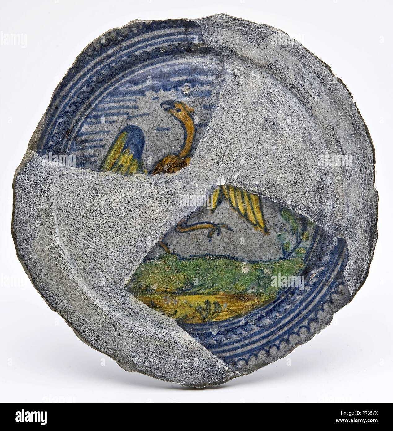 Frammento di piatto in maiolica policroma con bird, piatto della piastra porta-stoviglie suolo trovare ceramica smalto terracotta smalto stagno piombo smalto, anello 9.2 girate a mano cotto 2x la maiolica smaltata completato un frammento della maiolica pancake piatto piatto con anima di luce nello specchio. Piccole stampe di potare trafitto nelle prestazioni Standring. Decorazioni policrome un uccello o un animale mitologico su terra sfalsato giallo e blu ali archeologia il centro città di Rotterdam Stadsdriehoek Schielandshuis ceramiche indigene che serve cibo tabella servire decorare scoperta del suolo: Schielandshuis durante il restauro. Foto Stock