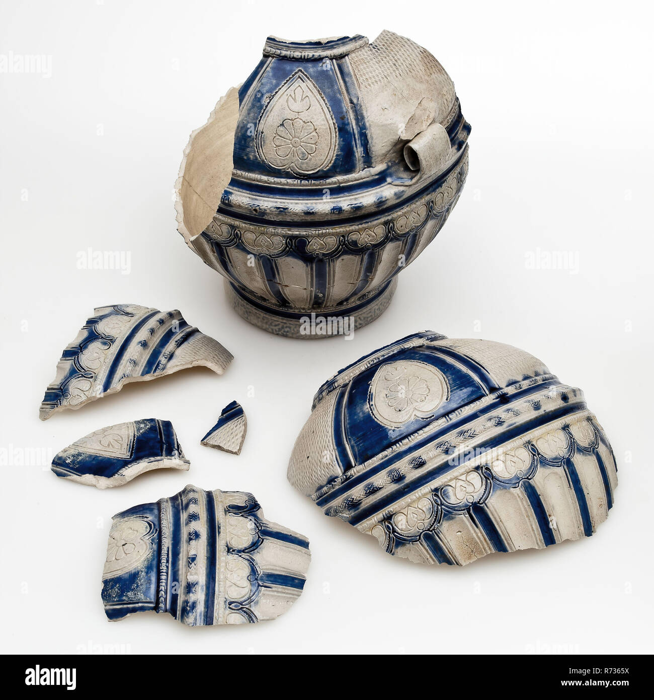 Westerwald brocca con lobi, patatine fritte e i campi scolpito, blu e grigio satinato e bricco per il supporto di stoviglie frammento trovare terreno gres ceramico smalto smalto sale, mano rivolta stampigliato scanalato di ossido di cobalto cotto smaltato porcellanato Jar grigio con ornamento blu figure geometriche cuori fiori curbschnitt. Uova a forma di modello su supporto piede. Gli anelli di profilo intorno al piede e collo. Metà inferiore decorato con montante lobi fregio con ridge e disegno a spina di pesce nel mezzo dello stomaco sulla spalla di campi con cherry e di cuore le forme in cui archeologia rosette Valckensteyn Poortugaal Albrandswaard donare indigeno Foto Stock