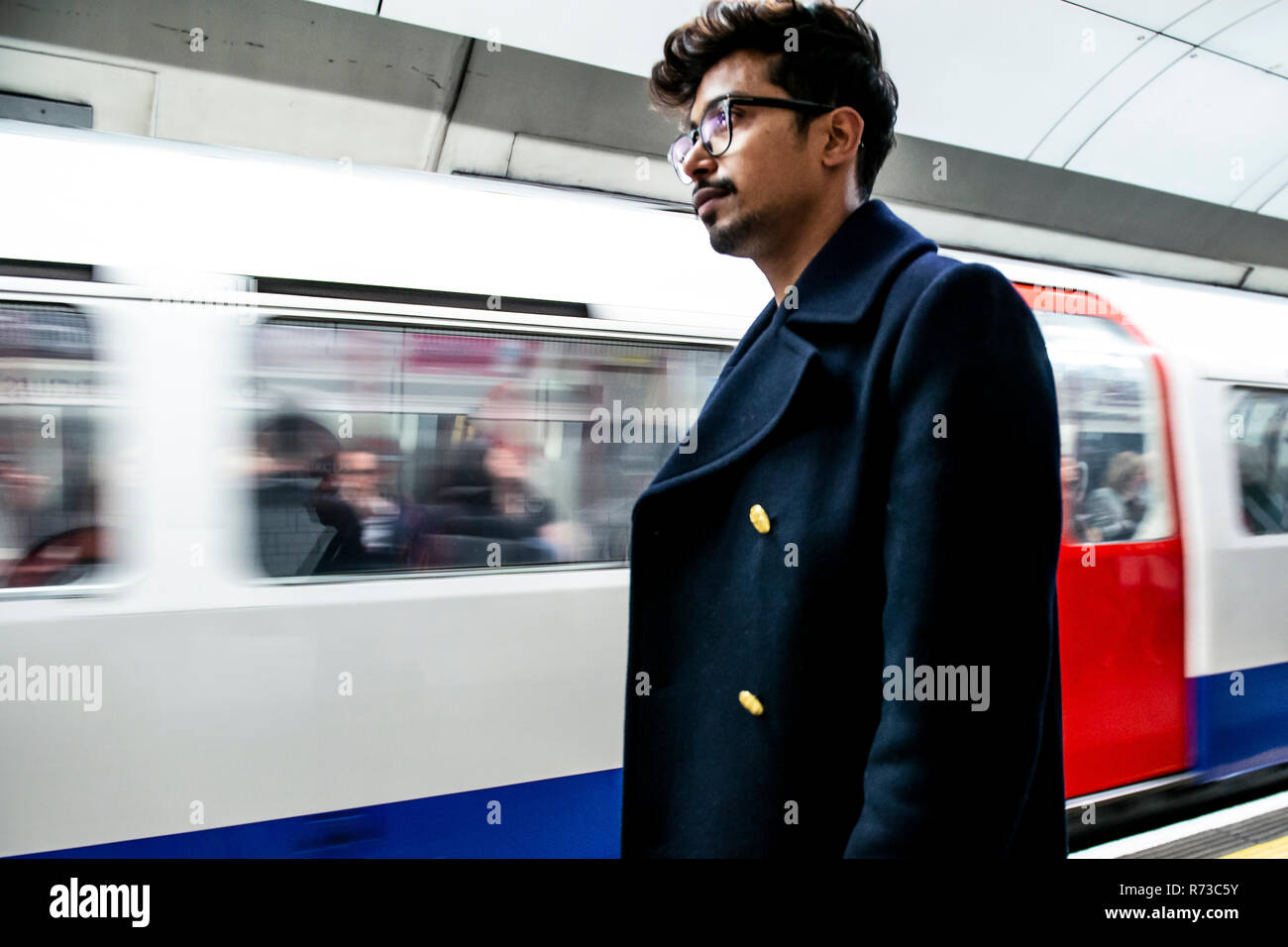 Imprenditore in attesa sulla piattaforma della stazione della metropolitana di Londra, Regno Unito Foto Stock