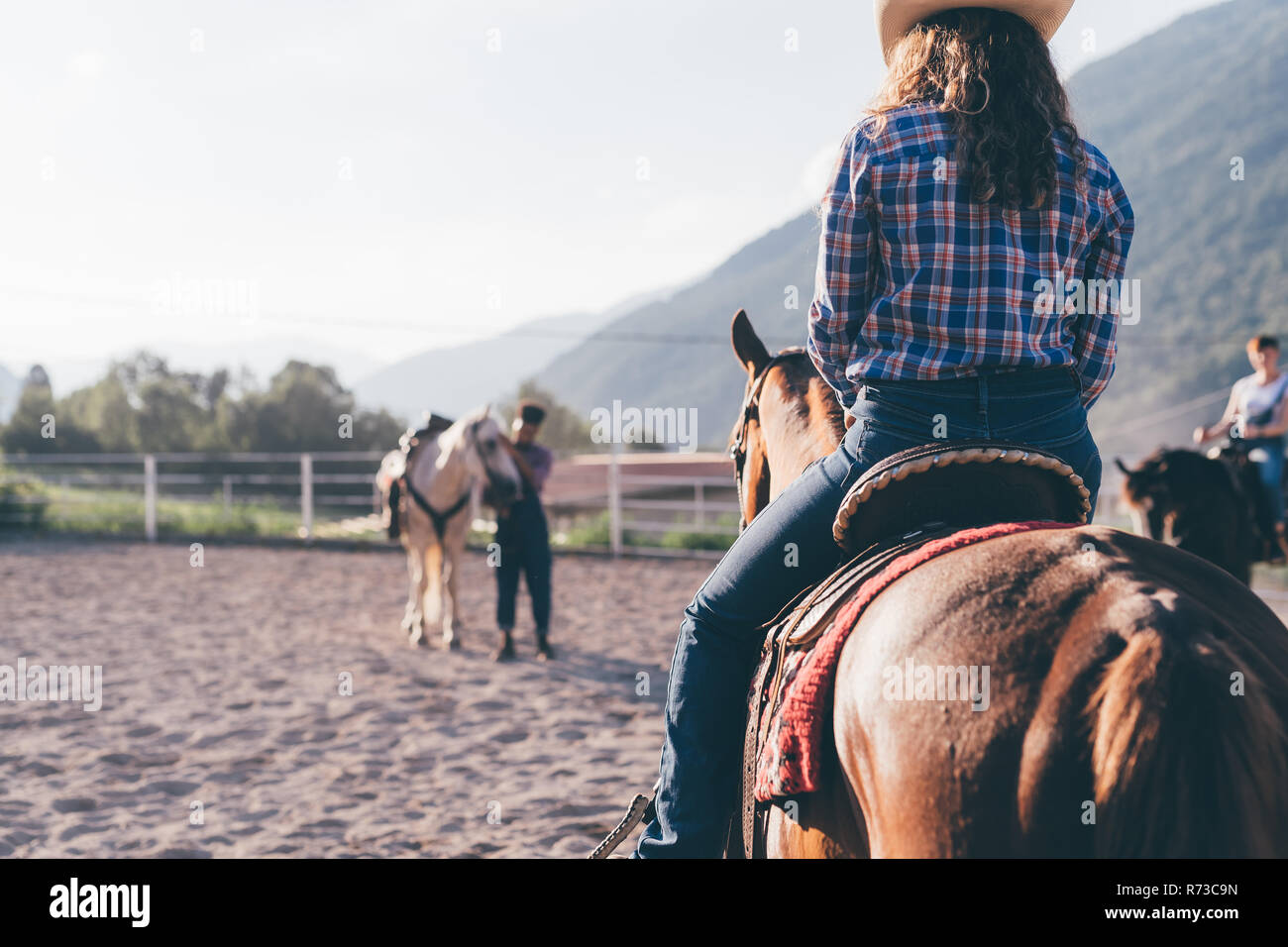 Cowgirl di equitazione in rurale arena equestre, Primaluna, Trentino-Alto Adige, Italia Foto Stock