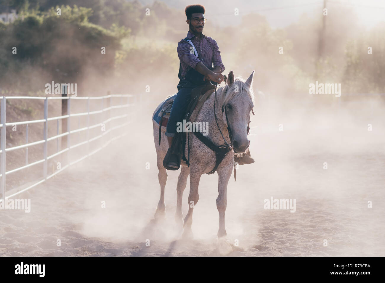 Giovane uomo a cavallo nella polverosa arena equestre, Primaluna, Trentino-Alto Adige, Italia Foto Stock