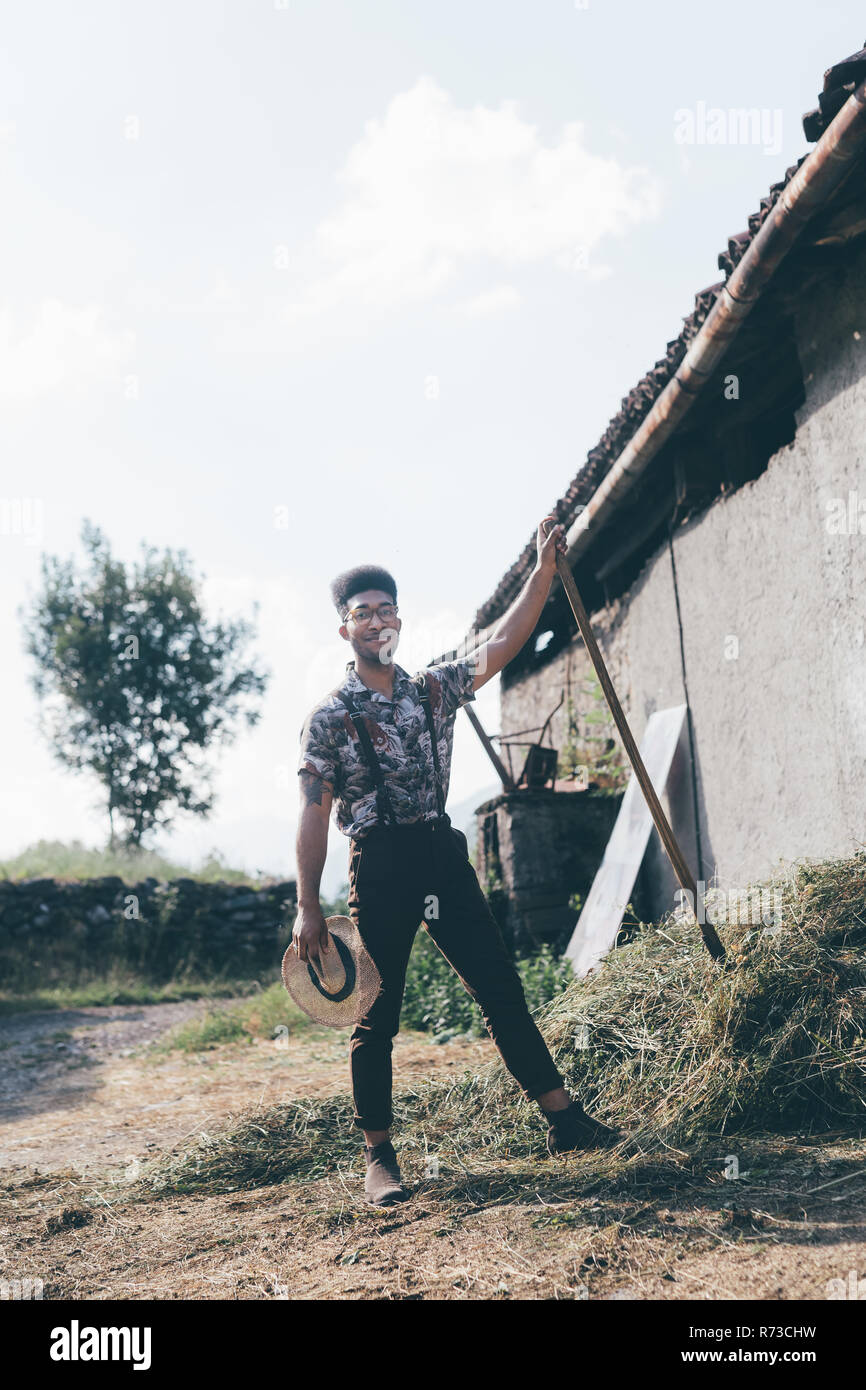 Giovane maschio lavoratore agricolo con forcone, piena lunghezza ritratto Foto Stock