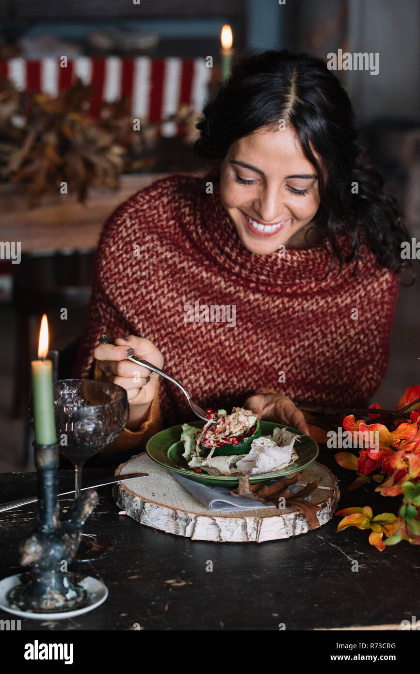 Giovane donna di mangiare insalata fresca al tavolo vintage Foto Stock