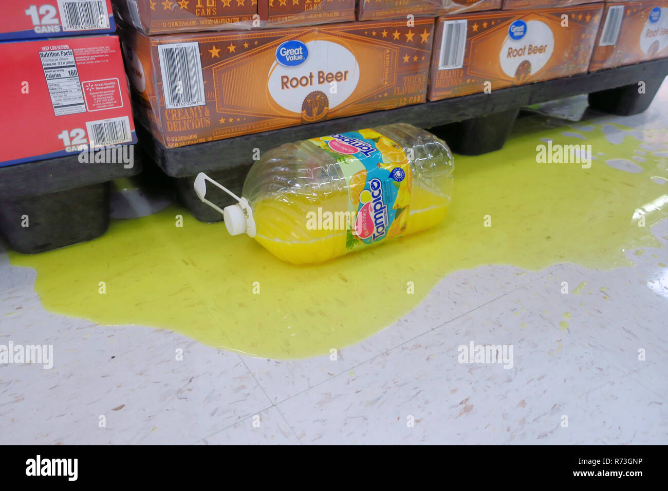 Una brocca di plastica di succo di frutta si trova versato su un piano del negozio. Foto Stock