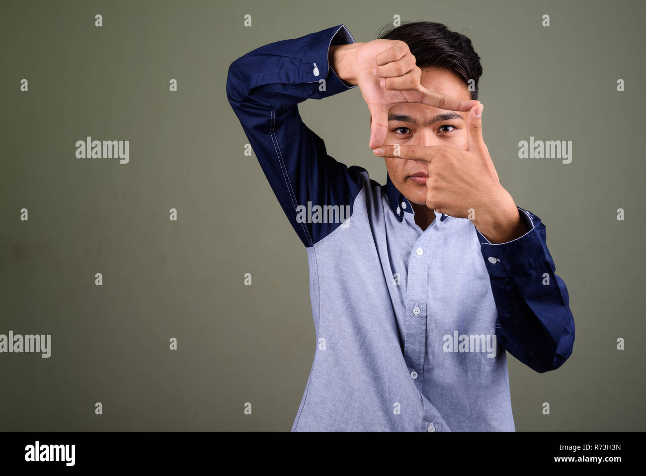 Giovani indiani handsome man looking smart contro backgrou colorati Foto Stock