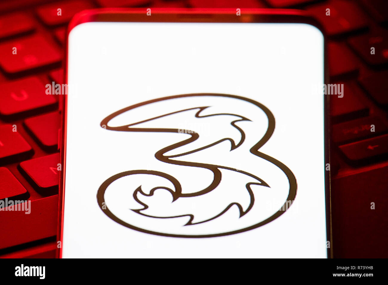 Il logo della rete telefonica mobile 3 viene visualizzato sullo schermo di uno smartphone. Foto Stock