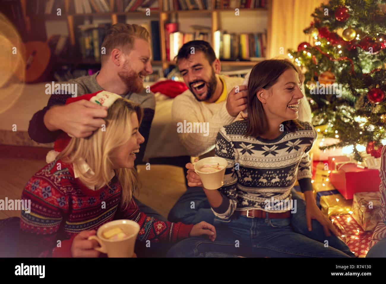 Sorridente amici divertendosi sulla festa di Natale a casa Foto Stock