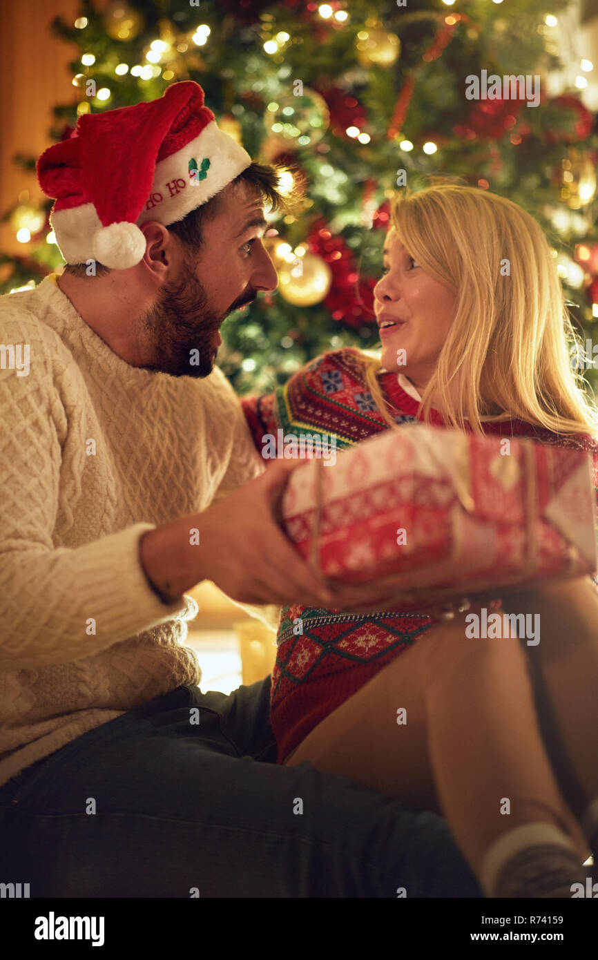 Tradizione di natale - Allegro giovane con dono godendo insieme alla vigilia di Natale Foto Stock