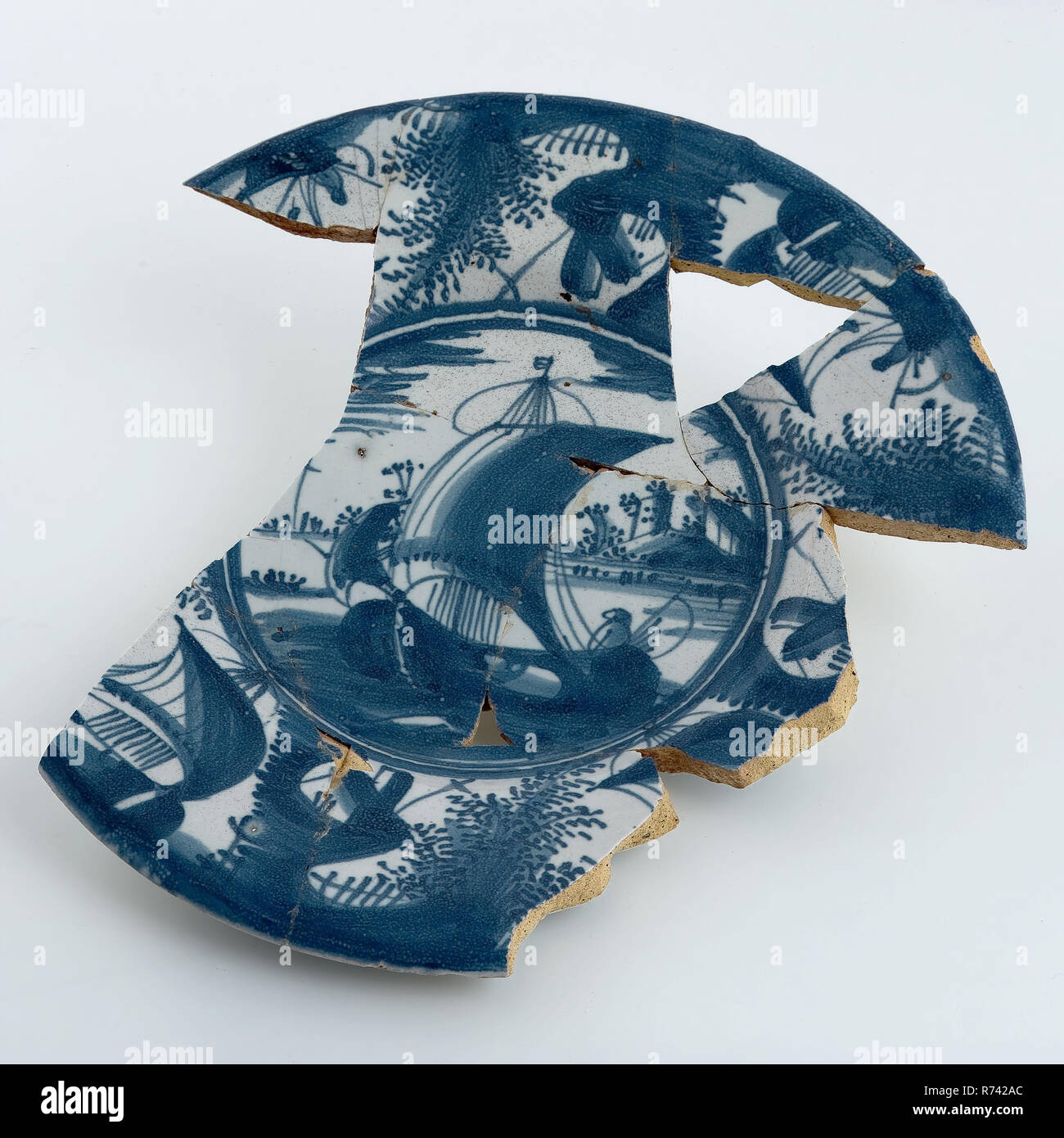 Colore bianco-blu maiolica piastra sul supporto, vedute del fiume come decor, lato inferiore Wanli decor, piastra di supporto delle stoviglie suolo trovare ceramica smalto terracotta smalto stagno, mano rivolta fritto verniciato satinato Faience cotta su piastra di supporto nell'anima e lungo il bordo decorato con decor blu le navi a vela nel paesaggio fluviale in tubo piccolo fritto montante rim e ampia bandiera. Decorate con arredamento cinese nello stile del periodo wanli archeologia Rotterdam Stadscentrum Stadsdriehoek Nieuwehaven ceramiche indigene servire servono cibo scoperta del suolo: Nieuwe Haven 1a fossa biologica (circa) 21-08-1980 Foto Stock