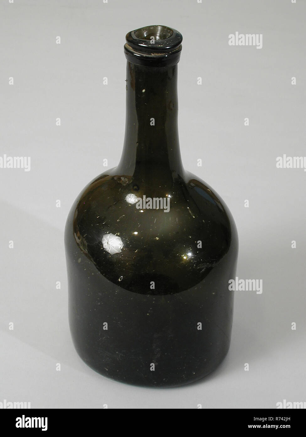 Bottiglia di vino di bottiglia in vetro verde scuro, abbastanza alto anima, portabottiglie trovare terreno, vetro soffiato nella forma di bottiglia in vetro verde scuro piuttosto alta sollevato l'anima. Pontil mark. Cilindrico spalla spiovente al collo. Collo cilindrico. Abbastanza bit la apertura della bottiglia non è nel mezzo. Per il trasporto di fili di vetro intorno al collo di archeologia di confezionamento del vino Foto Stock