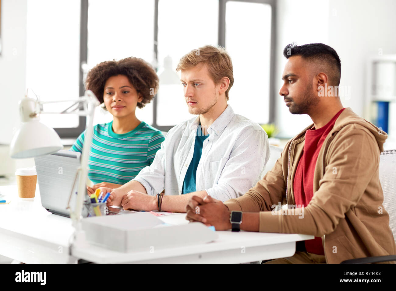 Il team creativo con il computer portatile lavorando in ufficio Foto Stock