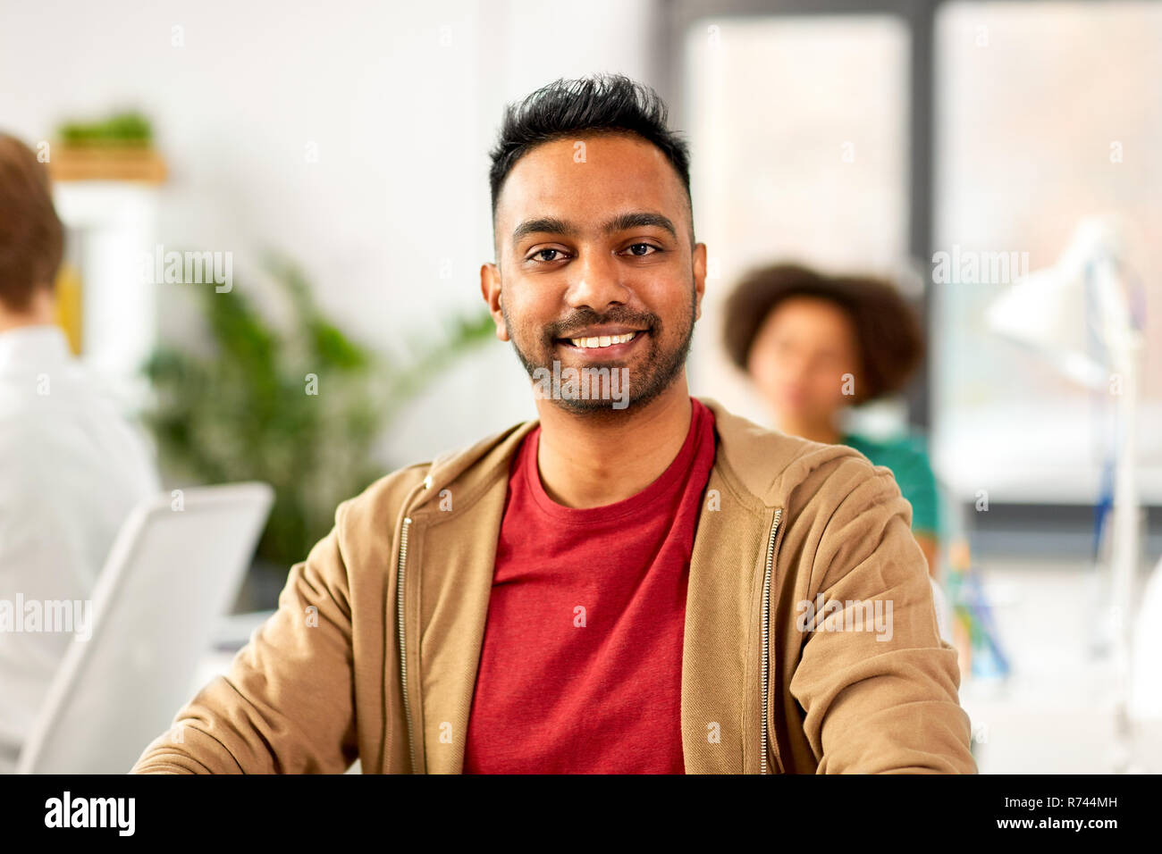 Sorridente uomo indiano in ufficio Foto Stock