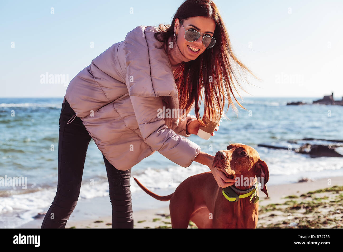 Elegante metà donna adulta sulla spiaggia come accarezzare il suo cane, ritratto, Odessa, Odeska, Oblast di Ucraina Foto Stock