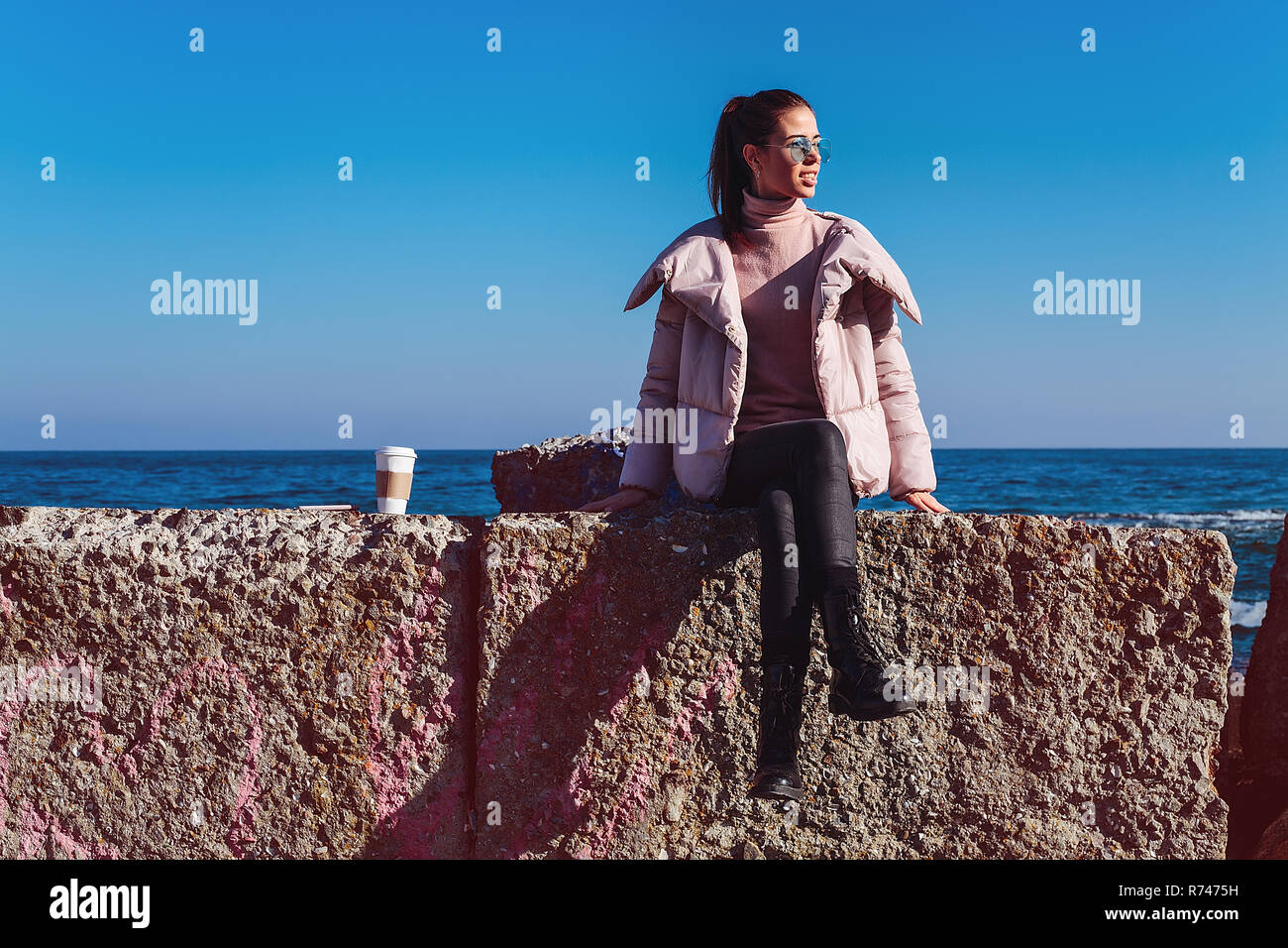 Elegante metà donna adulta seduta sulla parete del mare, Odessa, Odeska, Oblast di Ucraina Foto Stock