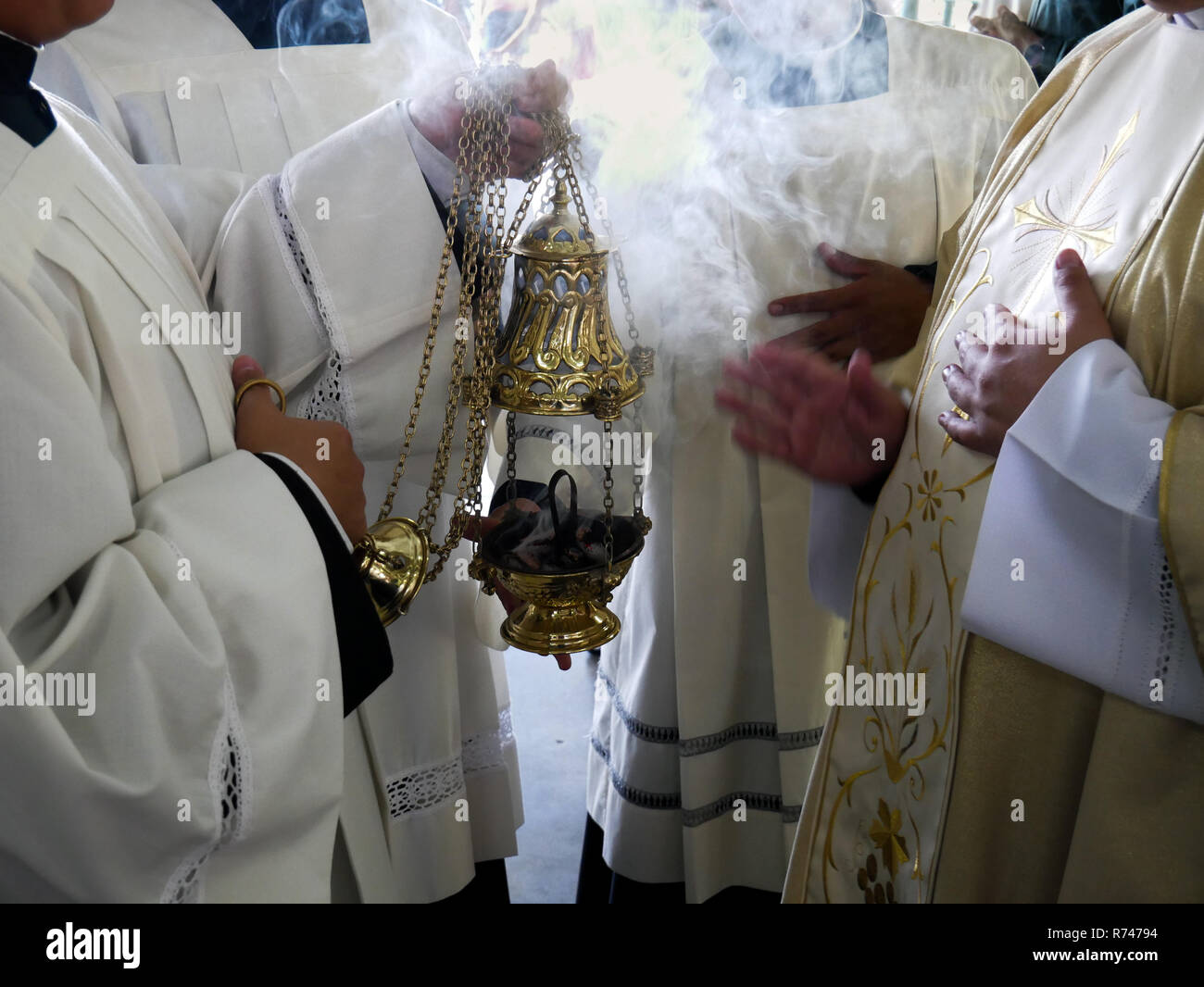 Un sacerdote benedizione l'incenso davanti a una processione su una messa cattolica con tutti gli ornamenti e non le persone riconoscibili Foto Stock