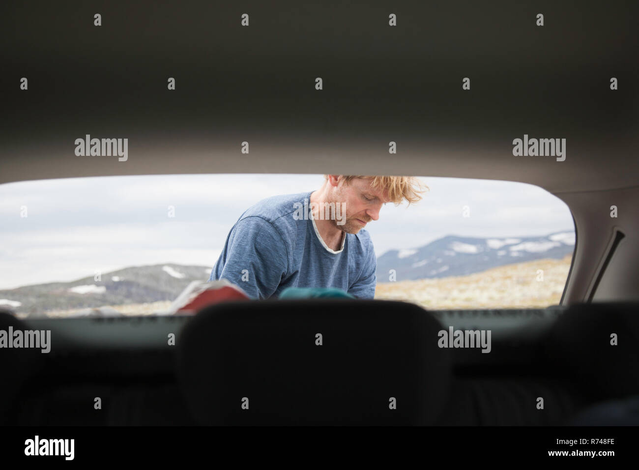 Cappa auto vista di uomo maturo disimballaggio auto, Oppland, Nord-Trondelag, Norvegia Foto Stock