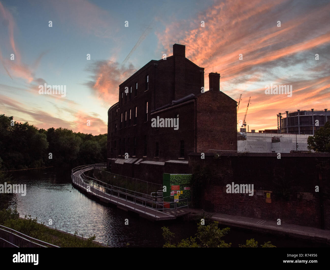 London, England, Regno Unito - 15 Giugno 2017: il sole tramonta dietro il mattone LNER carbone ufficio edificio sul Regent's Canal in King Cross per la rigenerazione urbana neig Foto Stock