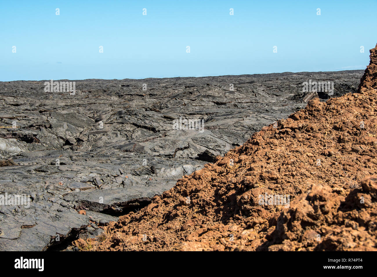Il grigio del flusso di lava dell'isola di Santiago nelle Galapagos contrasta con il rosso delle rocce Foto Stock