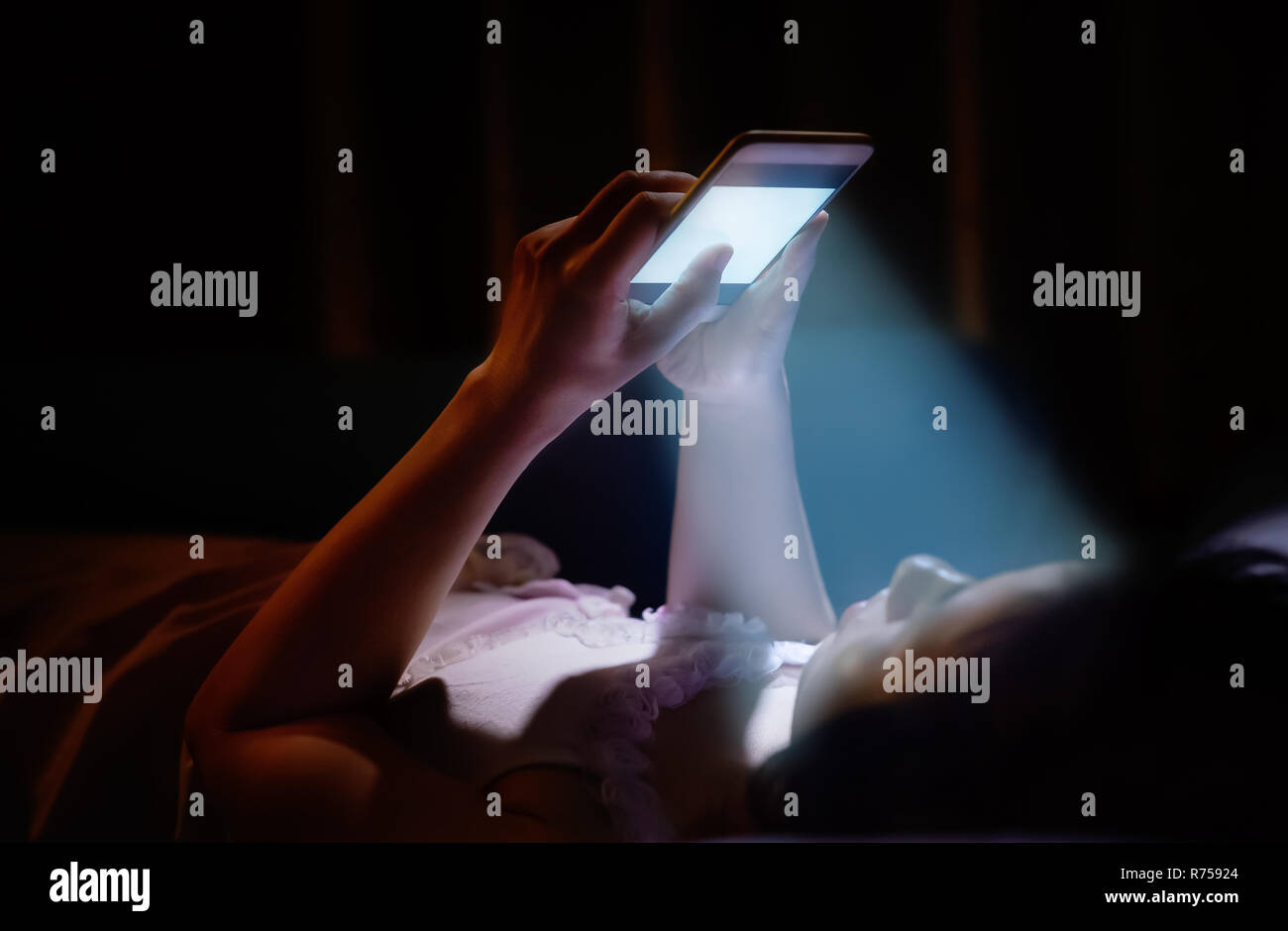 La luce blu dal telefono di notte di danneggiare i tuoi occhi Foto stock -  Alamy