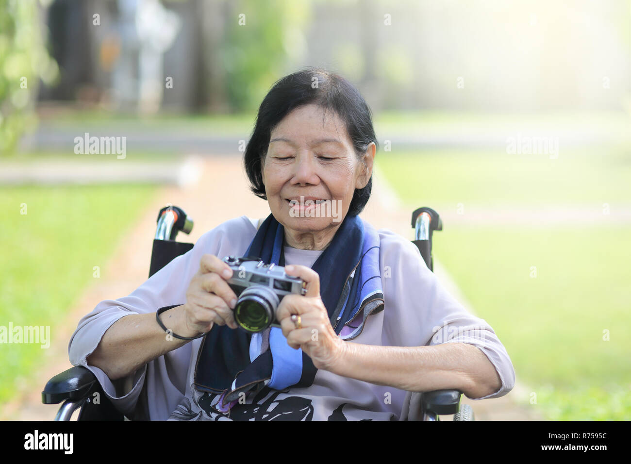 Donna anziana rilassarsi con hobby nel cortile posteriore Foto Stock