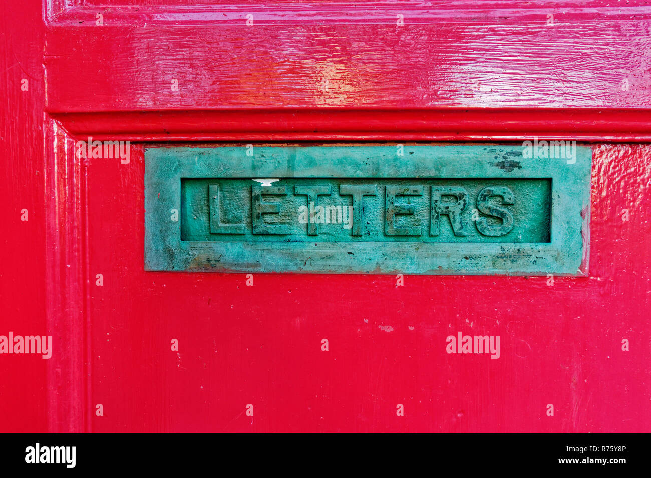 Vecchio decorativo formato letterbox su porta rossa Foto Stock