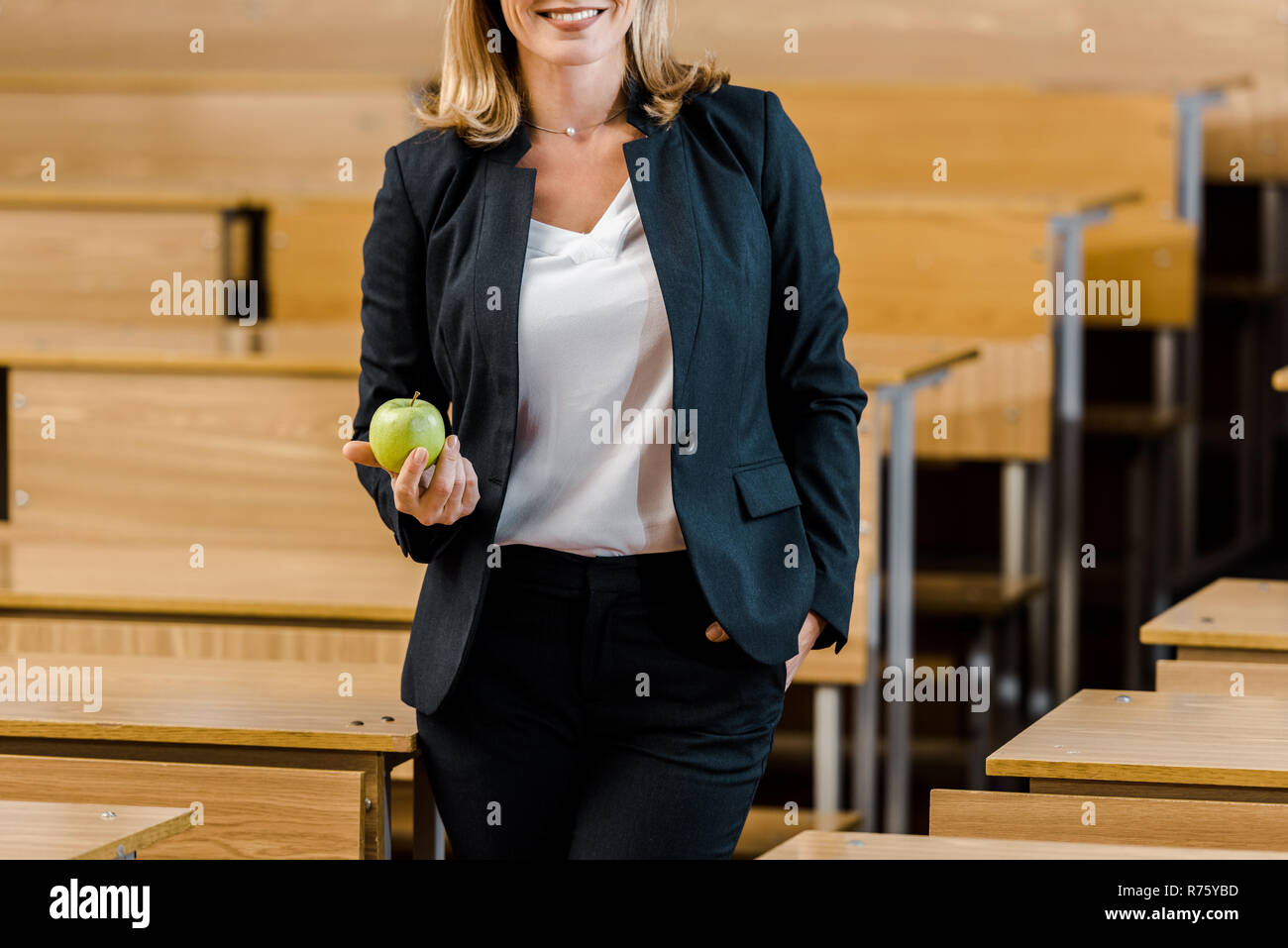 Vista ritagliata della insegnante femminile in abbigliamento formale  azienda apple in aula Foto stock - Alamy