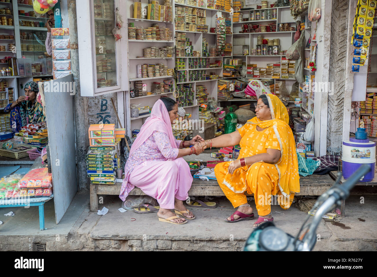 Due Signore che siedono di fronte ad un piccolo negozio a Bikaner, Rajasthan, India Foto Stock