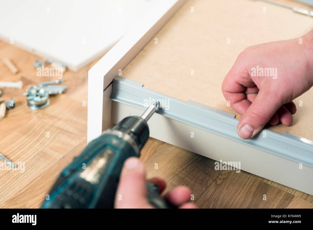 Assemblaggio di mobili di truciolare, utilizzando un cacciavite a batteria Foto Stock