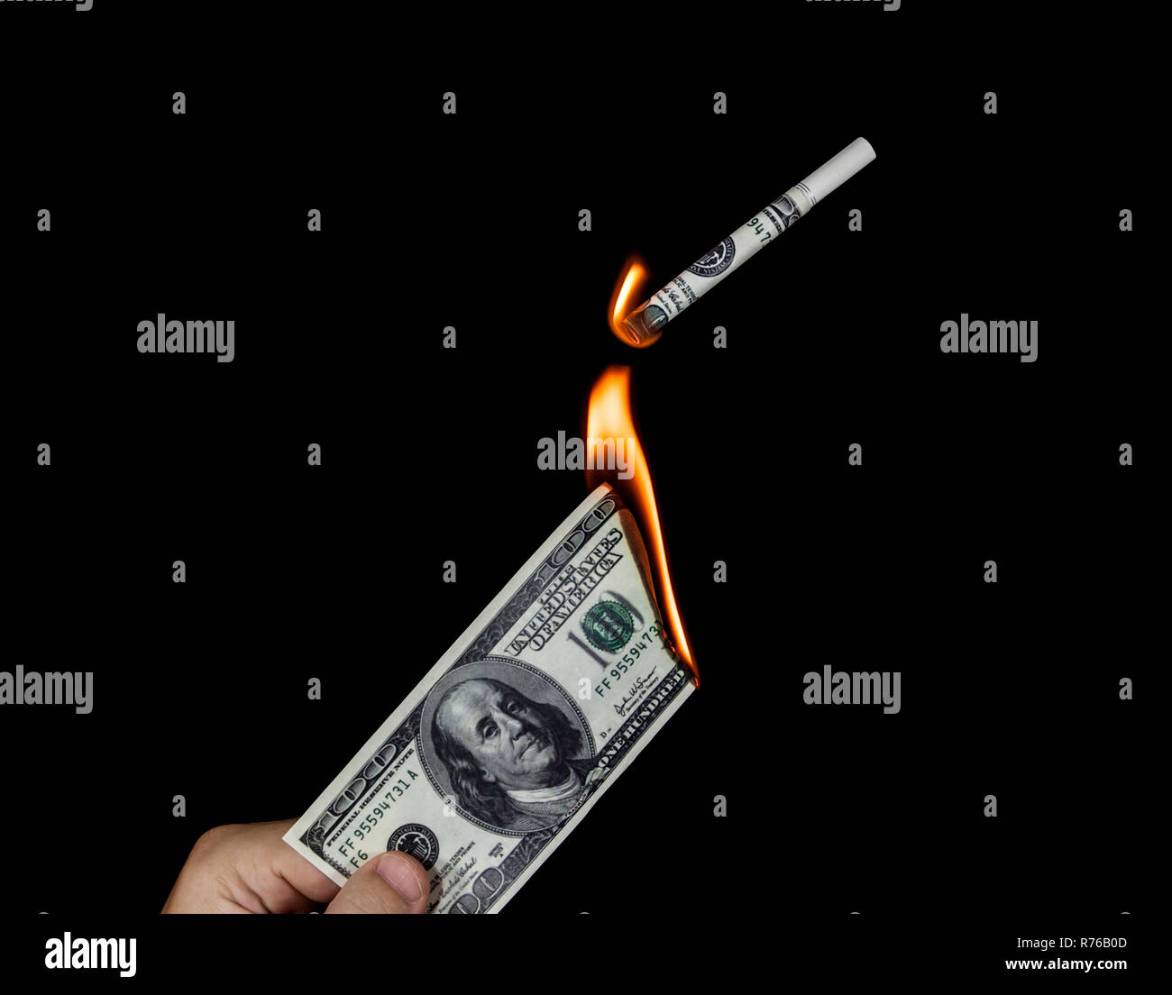 Mano umana tenendo un ardente 100 dollaro e accendere una sigaretta Foto Stock
