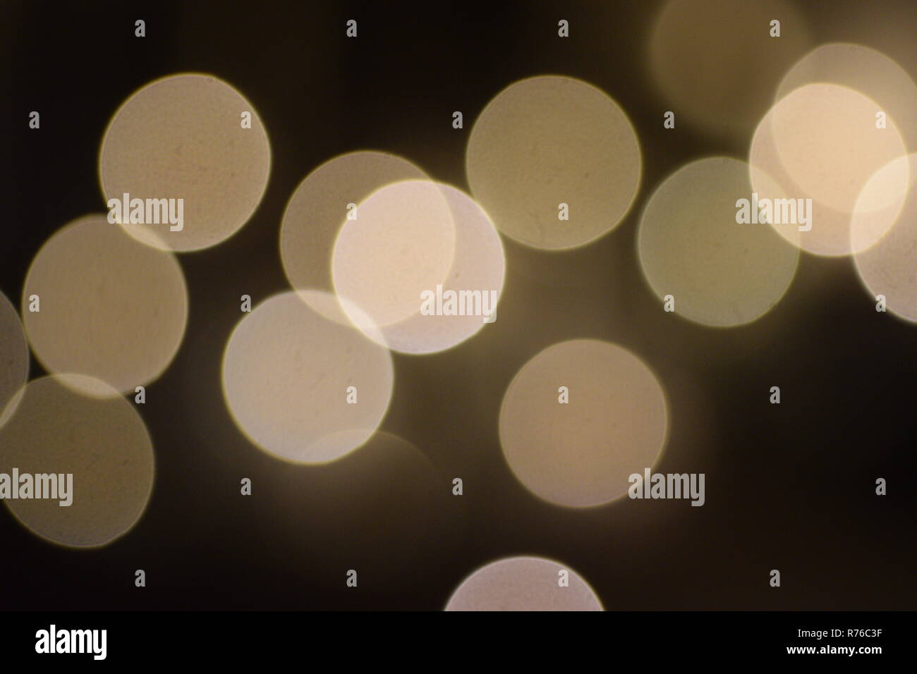 Molti luminosi cerchi sfocate sovrapposizione contro uno sfondo scuro, elemento di design Foto Stock